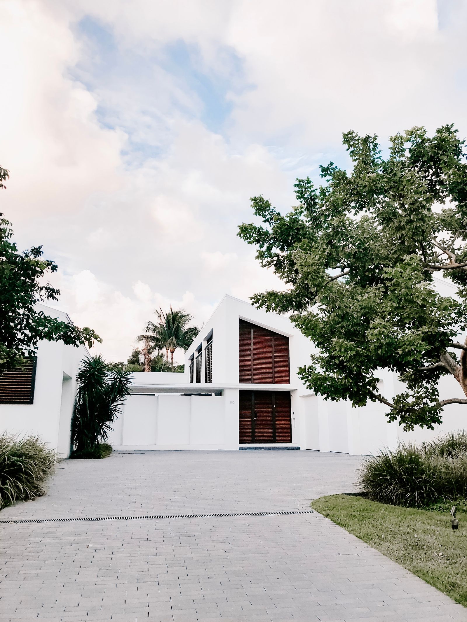 Maison contemporaine et son jardin paysagé, allée ouverte.