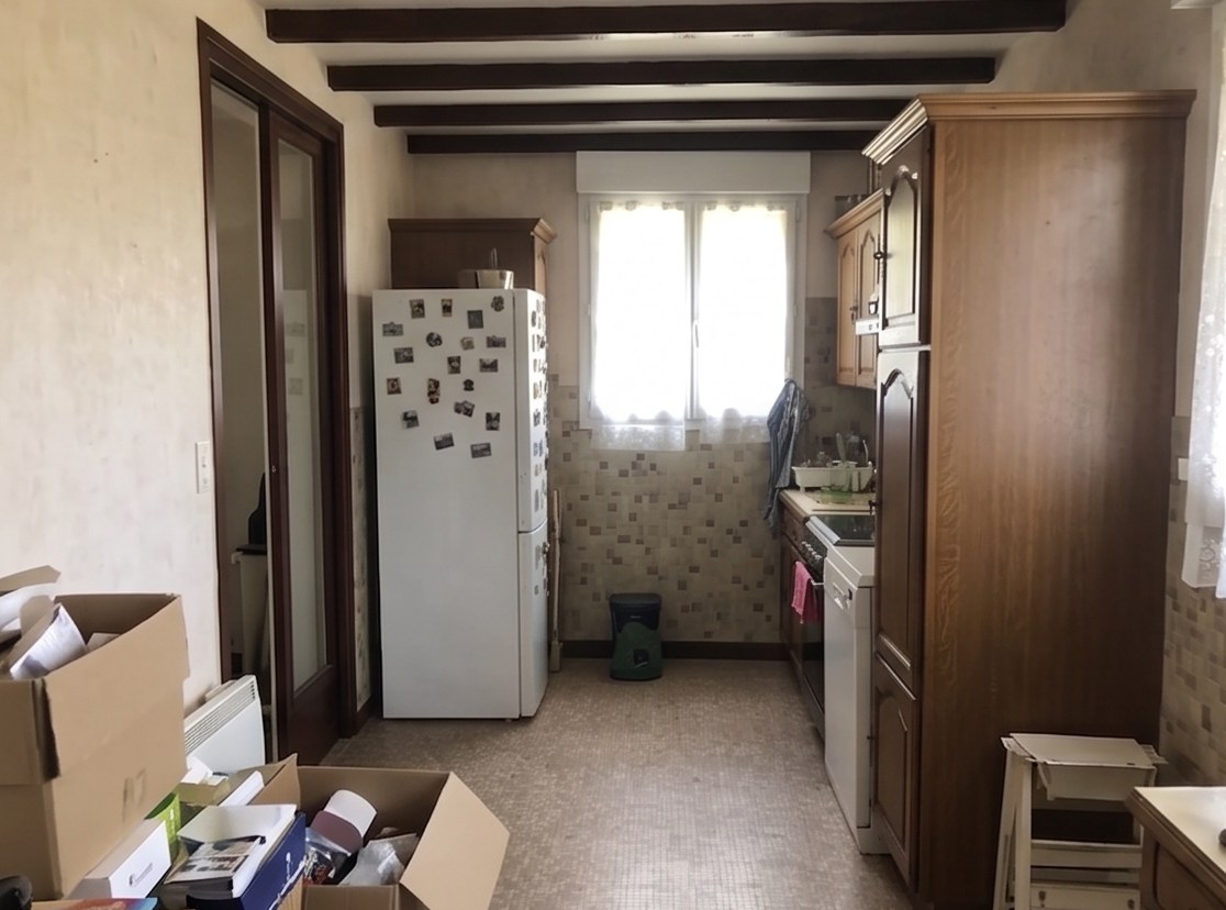 Même cuisine, autre angle avant travaux : ancien réfrigérateur, colonne en chêne rustique et sol vinyle.