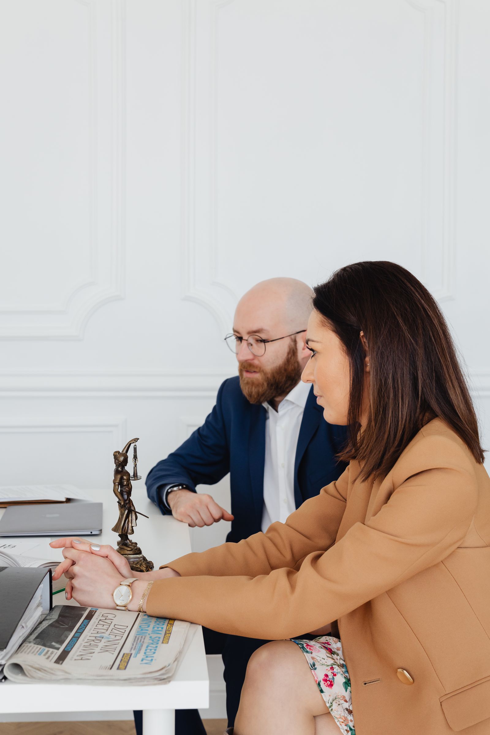 Un homme et une femme examinent des documents juridiques au cabinet.