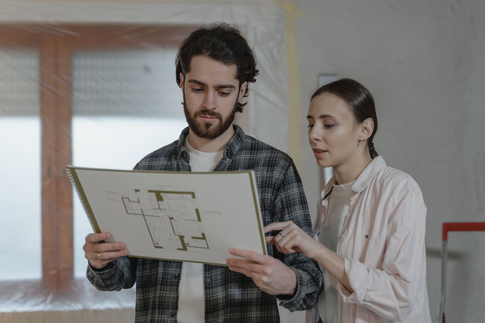 Un couple examine un plan de maison avec son conseil.
