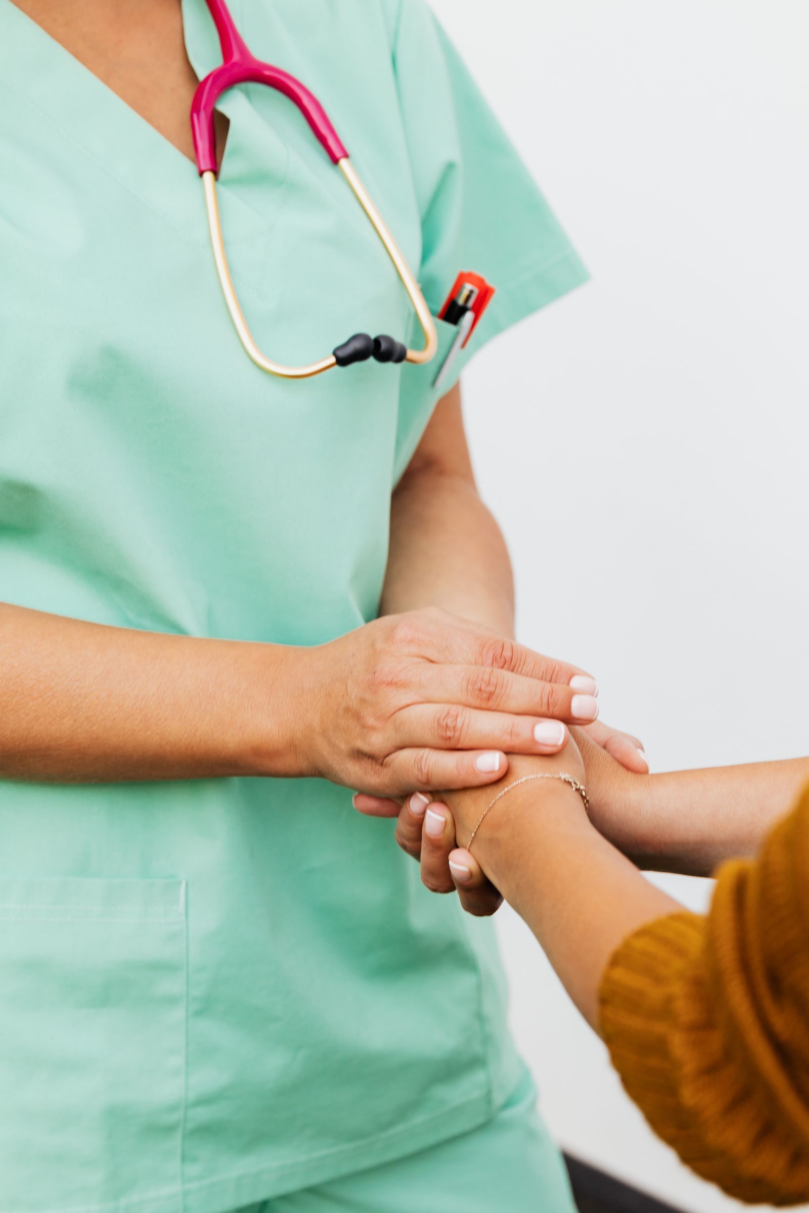 Main d’une soignante serrant doucement celle d’un patient.