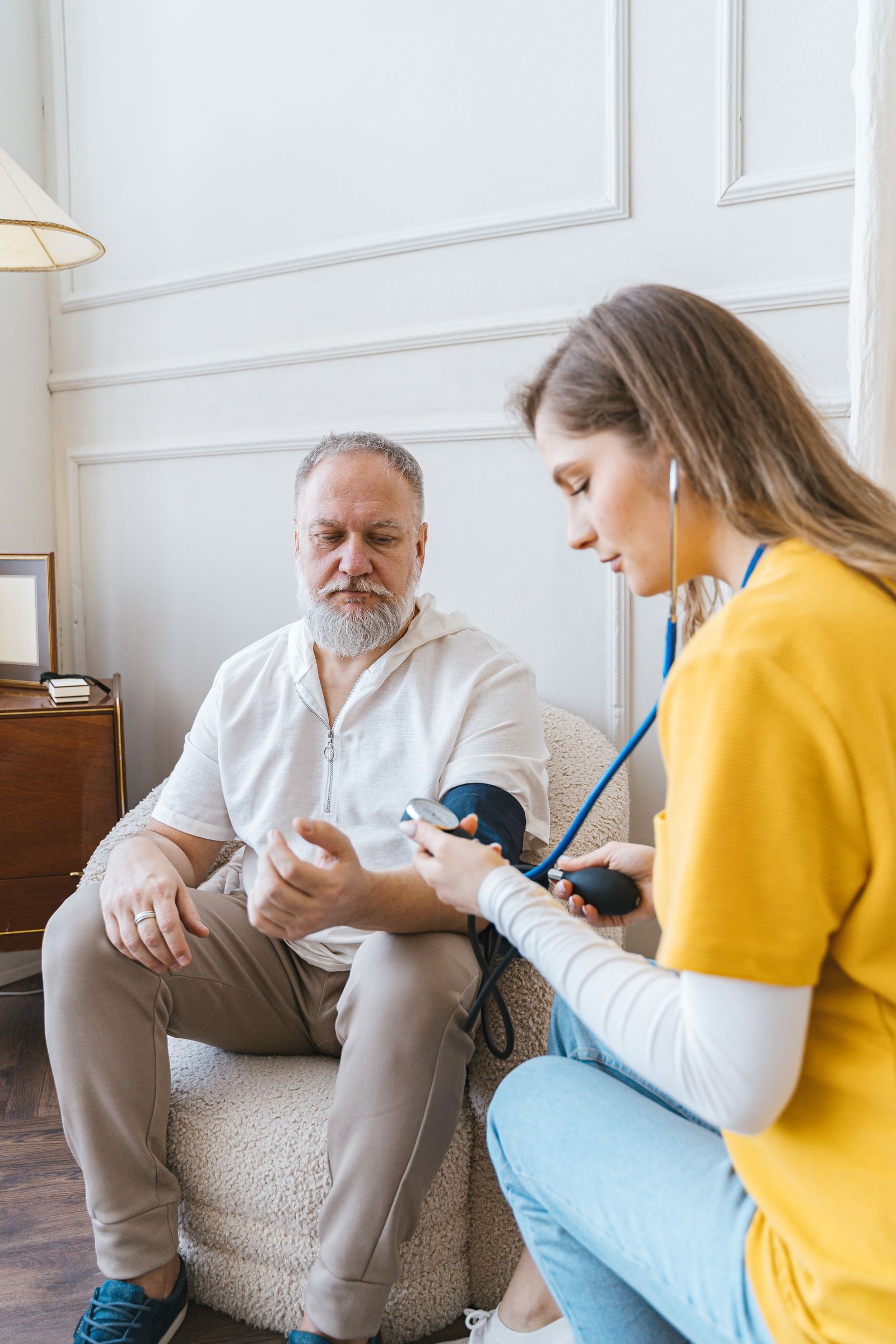 Prise de tension au brassard chez un patient âgé, à domicile.
