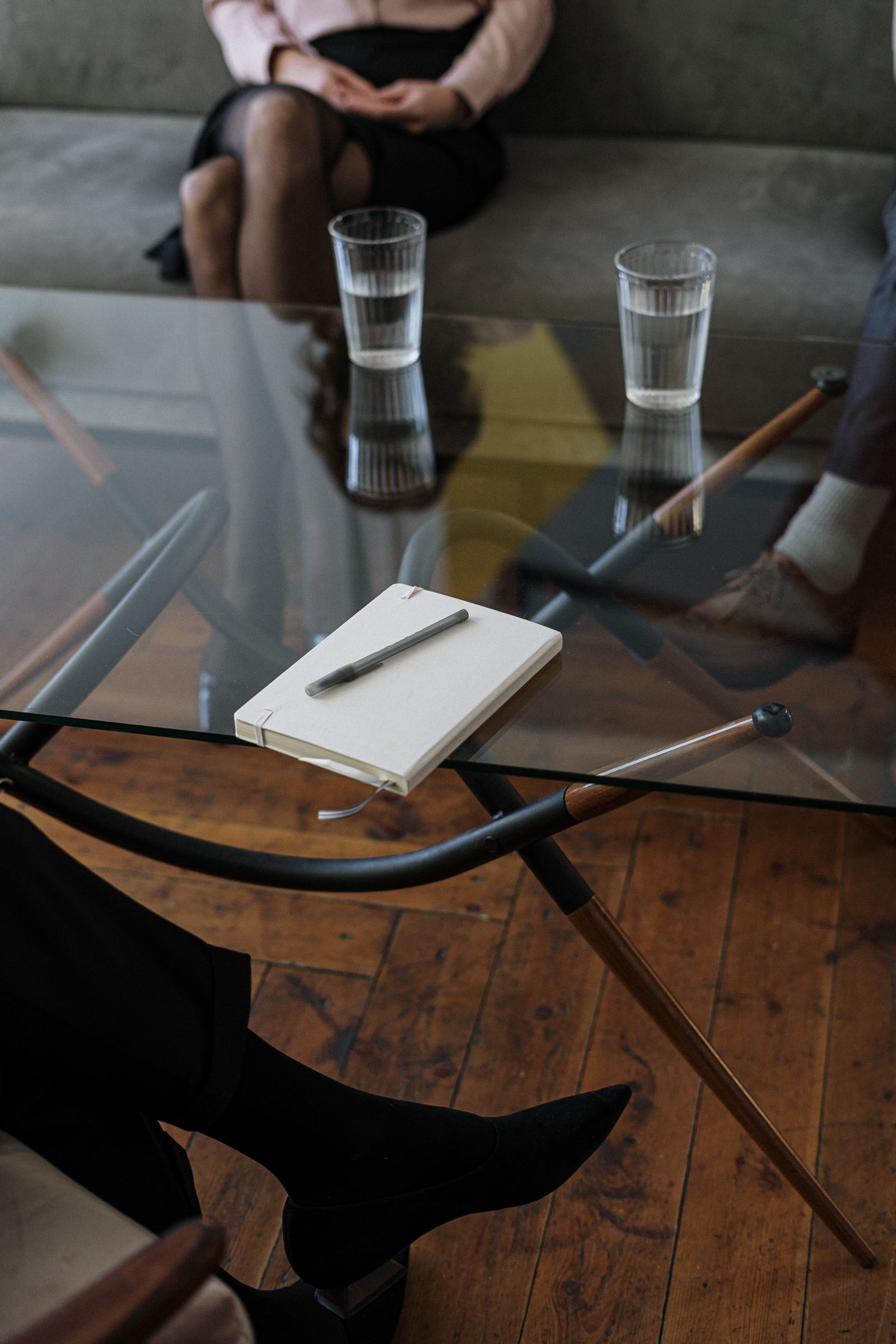 La table basse du cabinet, deux verres d’eau et un carnet.