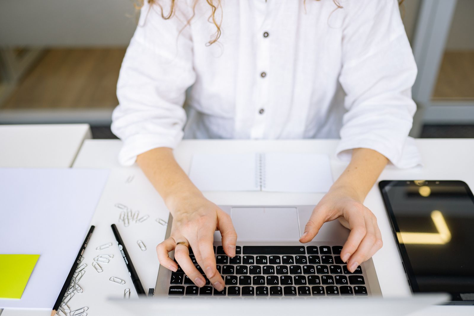 Mains sur un clavier d’ordinateur portable, bureau lumineux.