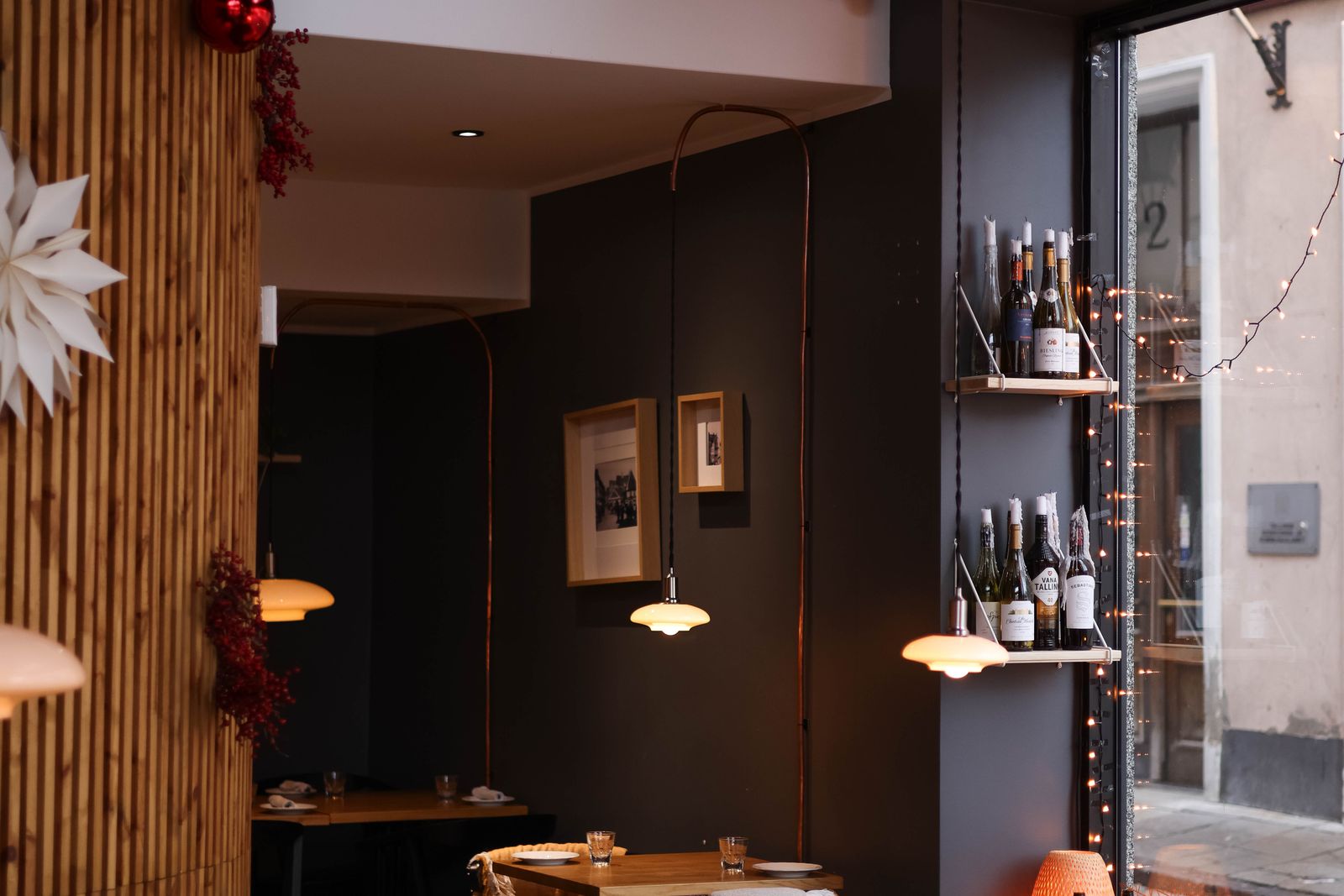 Salle du restaurant au soir, tables dressées et lumière chaleureuse.